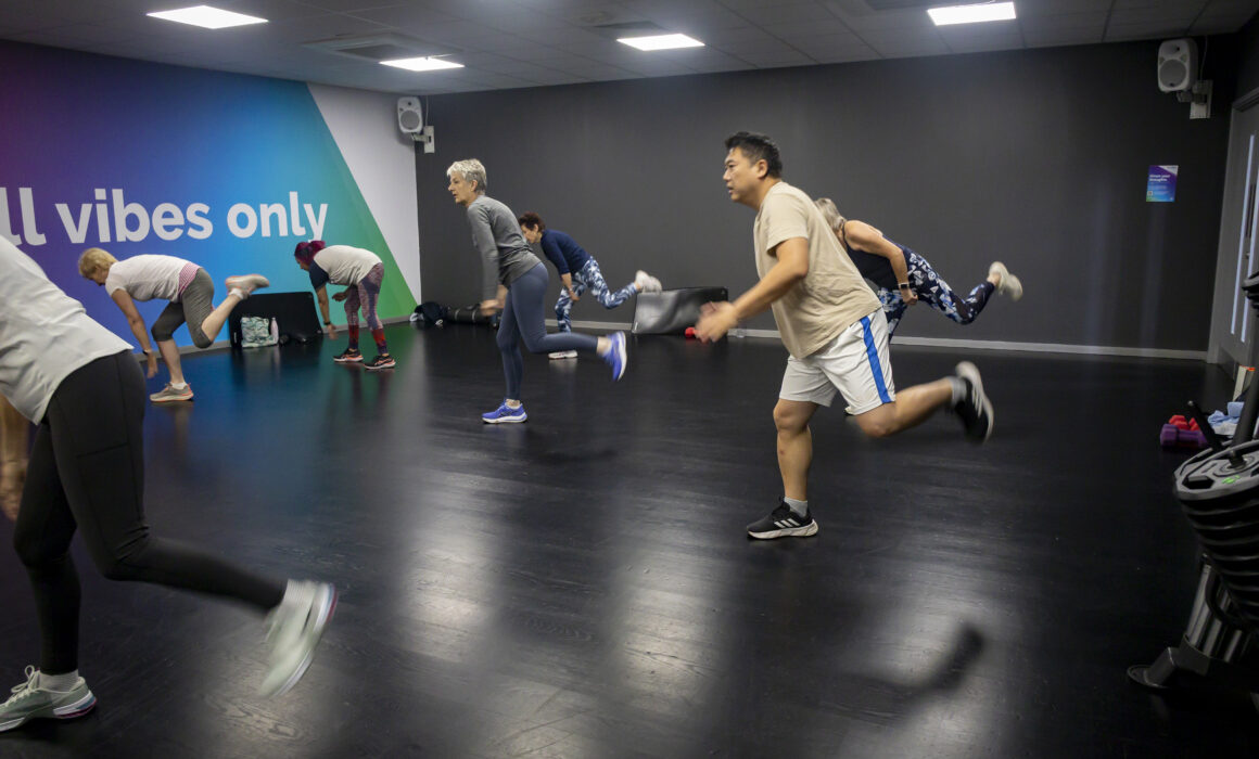 A photo of a group of people exercising in a fitness studio.