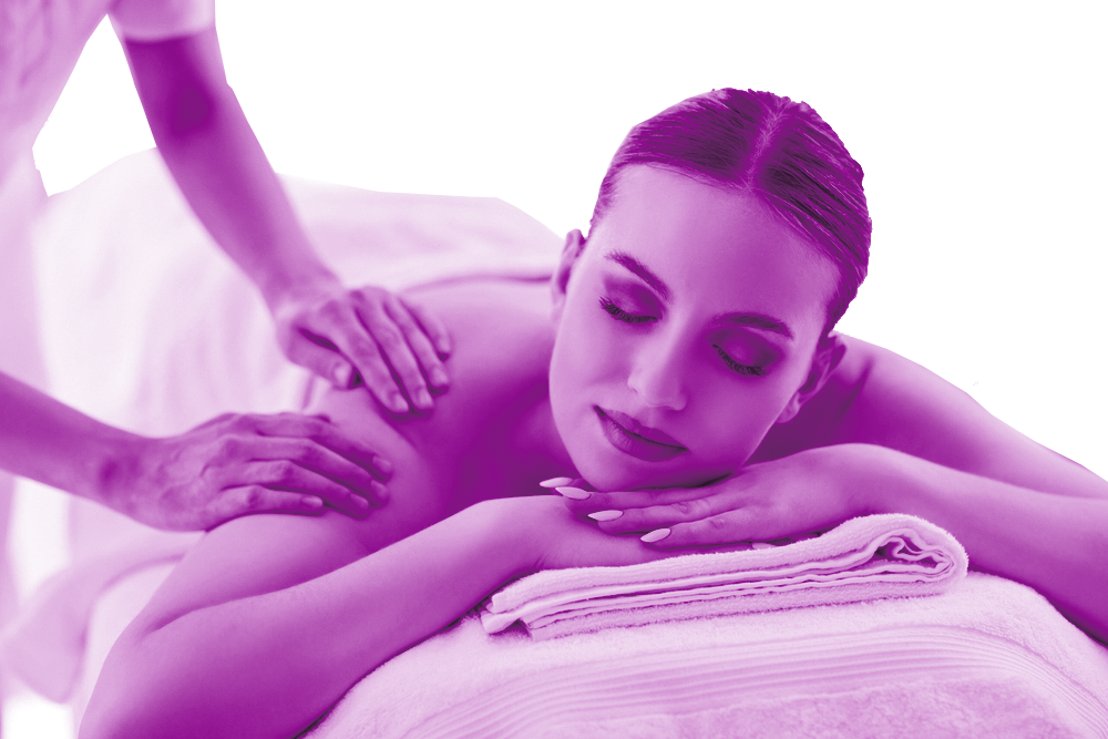 A woman lies on a massage bed whilst receiving a shoulder massage