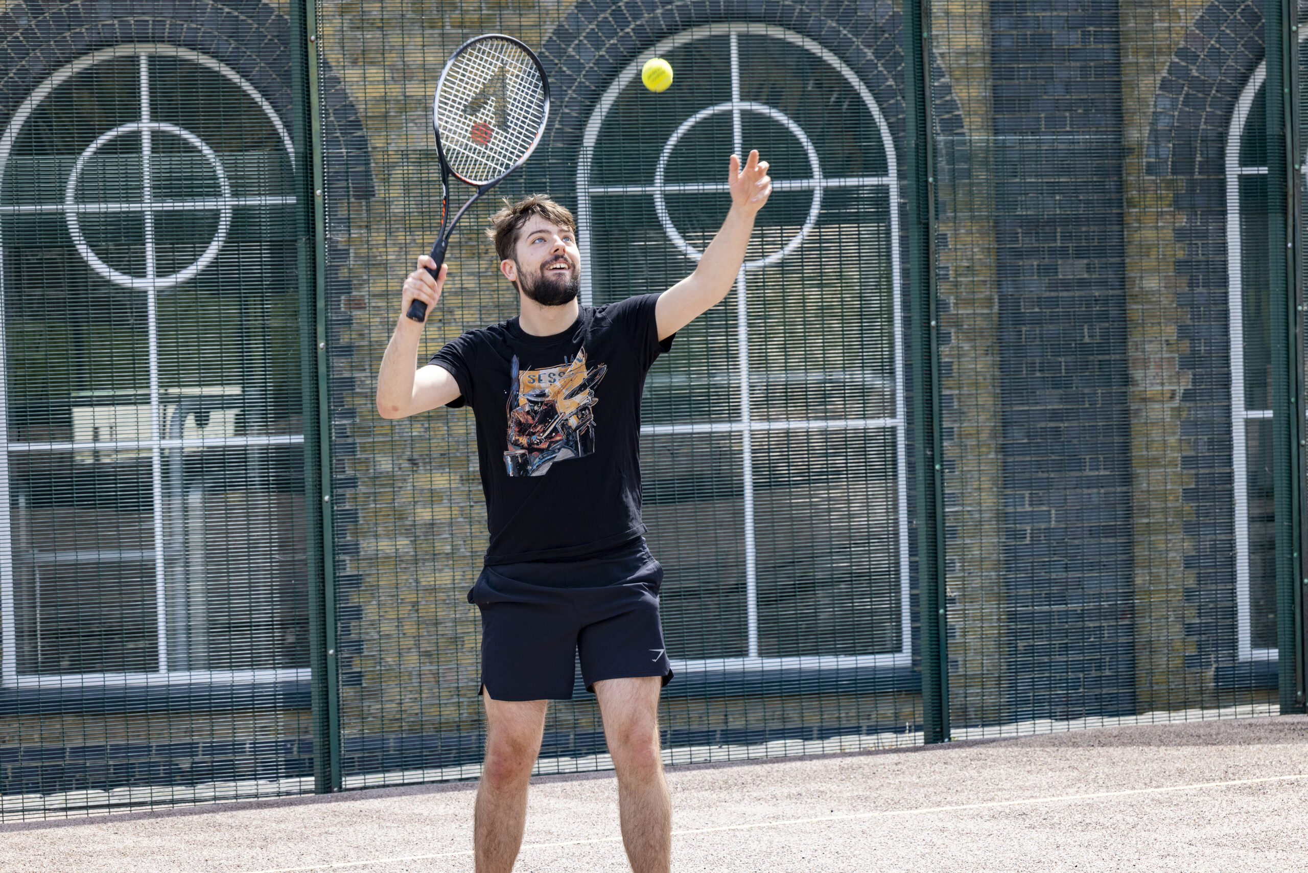 Photo of a man about to hit a tennis ball with a raquet